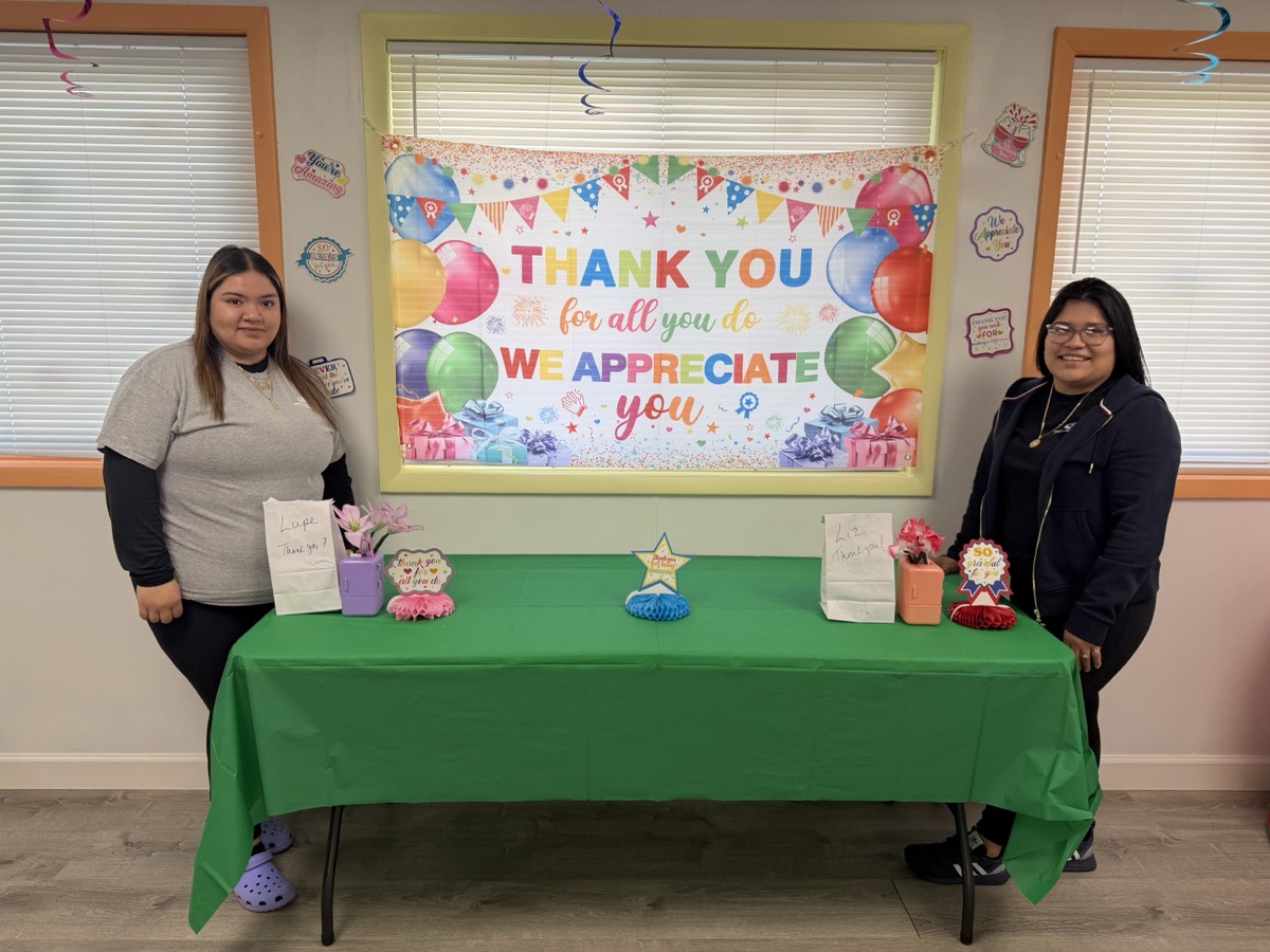 Two educators at the gift table